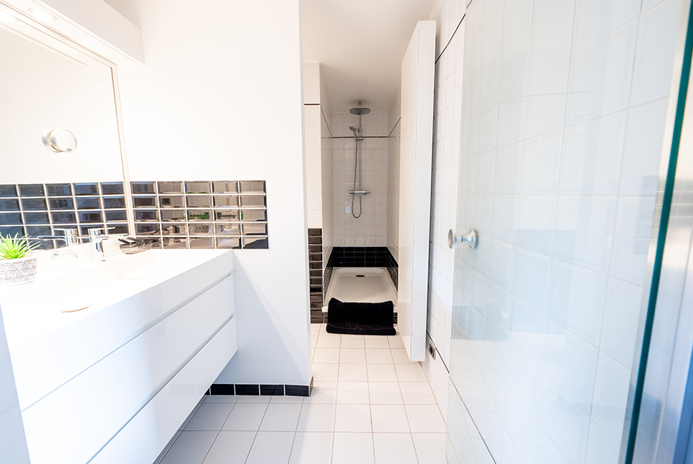 La salle de bain blanche et noire d'une chambre du Domaine de Béronsart