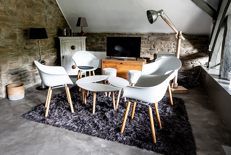 Coin salon avec une table basse blanche et des chaises blanches dans une chambre du Domaine de Béronsart