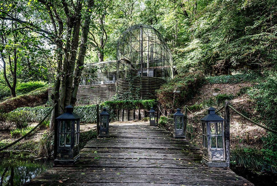 Le ponton en bois avec des petites lampes qui mène vers la volière du Domaine de Béronsart