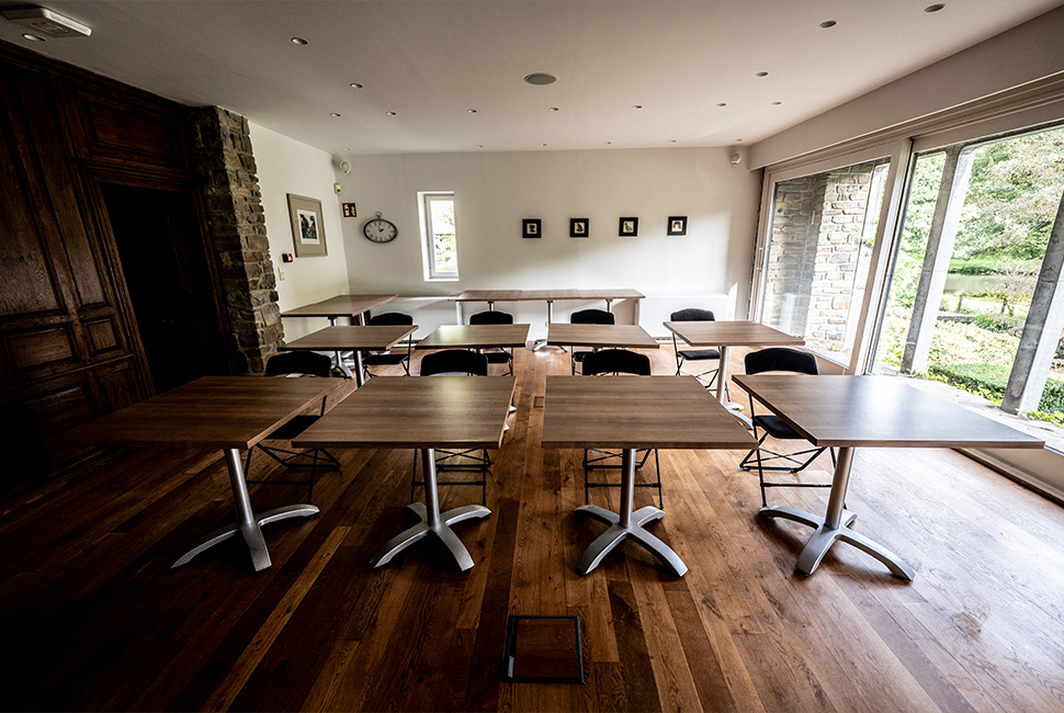 Salle de séminaire avec des tables en bois et du parquet en bois du Domaine de Béronsart