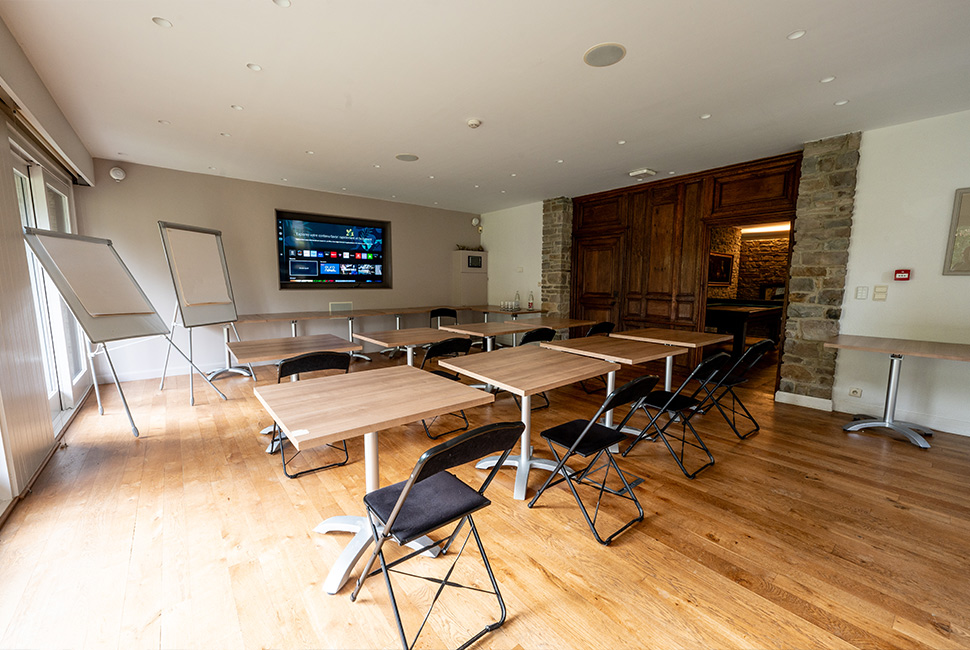 Salle de séminaire avec des tables, des tableaux blancs et un écran TV au Domaine de Béronsart