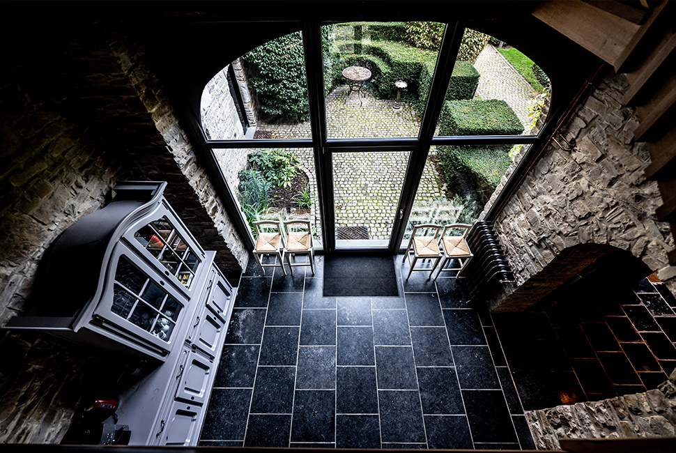 Vue aérienne de l'intérieur du Grand Hall du Domaine de Béronsart : sol en pavé noir, pierres apparentes aux murs